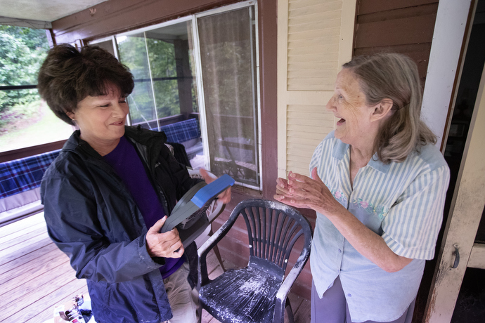Marjorie Sexton (right) reacts with joy to the cool breeze from a battery-powered fan brought by volunteer Lisa Cox from Hindman (Ky.) United Methodist Church. Sexton’s home in Pippa Passes, Ky., had been without electricity for several days. Photo by Mike DuBose, UM News.