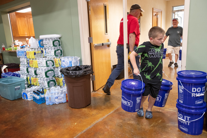 Myles Burnett, 8, helps unload flood buckets at Hindman (Ky.) United Methodist Church. Photo by Mike DuBose, UM News.