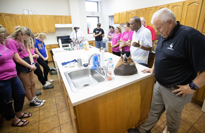 Bishop Leonard Fairley (second from right) leads a prayer for the church youth group and leaders at Graceway United Methodist Church in Langley, Ky. Volunteers at the church, including many of the youth, have been cooking and serving meals for flooding survivors. At right is the Rev. Roy Harlow, the church’s pastor. Photo by Mike DuBose, UM News.