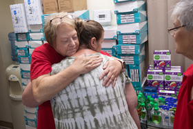 Volunteer Rose Calhoun (left) hugs flood survivor Rosemarie Peak, who was picking up relief supplies at United Methodist Mountain Mission in Jackson, Ky. At right is fellow volunteer Debbie Holcomb. The volunteers are members of Hampton (Ky.) United Methodist Church. Photo by Mike DuBose, UM News.