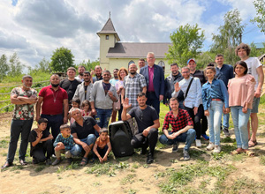 United Methodist Bishop Christian Alsted (center) visited a Roma congregation in the village of Serednje, Ukraine, for worship and Communion. Mattresses of the refugees staying in the Kamyanitsa church were stacked in another room prior to the service. The Rev. Oleg Stardubets, district superintendent of the United Methodist Church in Ukraine, stands to the bishopâs right in checked shirt. His wife, the Rev. Yulia Starodubets, who serves a United Methodist church in Kyiv, stands behind him. Photo courtesy of Bishop Alsted.