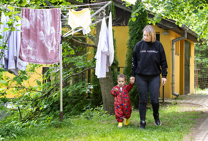 Natasha camina con su hijo, Artem, en el campamento de la iglesia metodista unida de Poušť, donde se hospedan.  Huyeron de su hogar cerca de Odesa, Ucrania, para escapar de la guerra con Rusia.  Foto de Mike DuBose, Noticias UM.