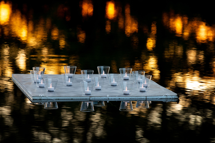 Votive lights float on Lake Benson in remembrance of missing and murdered indigenous women during Native Moccasins Rock.