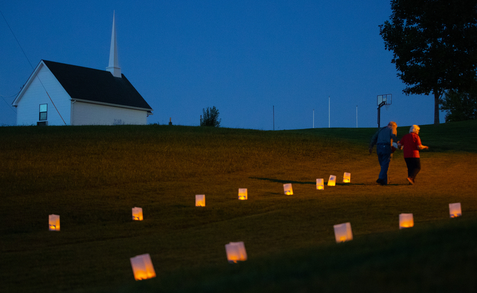 Luminarias line a path to the lakefront for a service of remembrance for missing and murdered indigenous women during Native Moccasins. In the background is the Grimsley Memorial Chapel of Finley United Pentecostal Church.