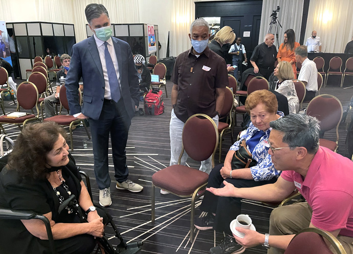 The mother of legendary AIDS activist Ryan White, Ms. Jeanne White-Ginder (left), converses with Dr. Bonnie J. Messer (second from right) and Chin Keong Tan at the 24th International AIDS Conference, July 29-Aug. 2 in Montreal. Scientific and medical personnel at the event expressed alarm about the negative impact new global health threats like COVID-19 and monkeypox is having on the progress toward improving HIV prevention, treatment and care. Photo by Don Messer.