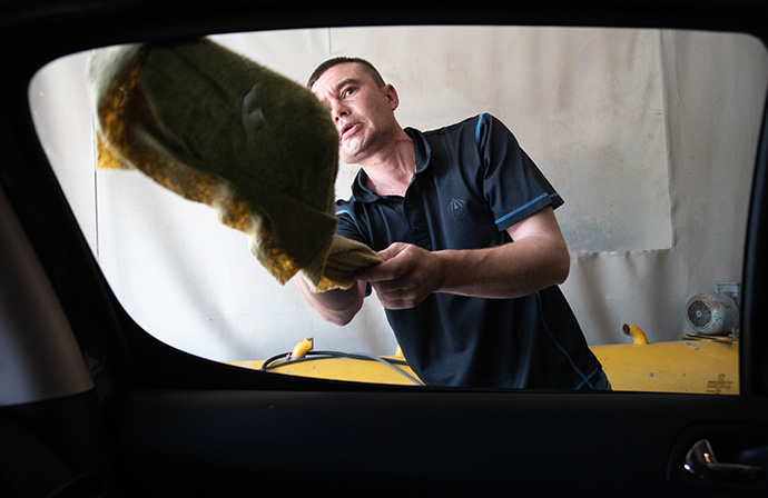 Sergei, who fled the war in Ukraine, washes cars at a business in Cluj-Napoca to help support his family. The family is being supported by the United Methodist Church in Romania. Photo by Mike Dubose, UM News.