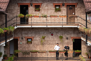 The Revs. Rares Calugar (left) and Samuel Goia talk on a balcony at the United Methodist Hotel Hanul Fullton and community center in Cluj-Napoca, Romania. The church bought the hotel, which houses refugees from Ukraine in some of the rooms, while others are used to house charity nongovernmental organizations and some are rented to help fund ministries of the church. Calugar is superintendent of The United Methodist Church in Romania and Goia is pastor of Way of Faith United Methodist Church in Micesti. Photo by Mike Dubose, UM News.