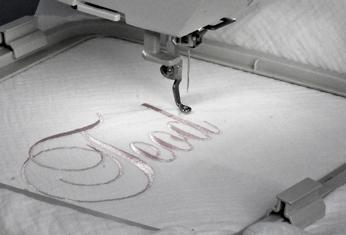 Maria and Daryna use a computer-driven embroidery machine to personalize baby items. Photo by the Rev. Üllas Tankler.