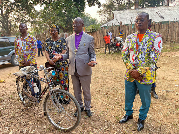 L'Évêque Méthodiste Uni Gabriel Yemba Unda (au centre) s'adresse aux pasteurs de Tunda lors d'une cérémonie visant à leur donner des bicyclettes et des Bibles. A droite, le Chef Prosper Tunda Kasongo Lukali, Chef Coutumier du village de Tunda-Dikungu. Photo de Chadrack Londe, UM News.