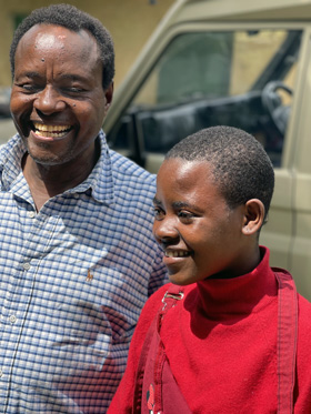 Stanley Gitari (left), Maua Methodist Hospital supervisor, celebrates the construction of a new home for Jackeline and her grandmother. After her parents died from AIDS, Jackeline, age 12 at the time and HIV positive, had no other choice but to live with her impoverished grandmother in a dirt-floor shack in the rural outskirts of Maua, Kenya. Since 2004, Gitari and his Maua Methodist Hospital team have built about 360 homes. Photo by the Rev. Donald E. Messer.