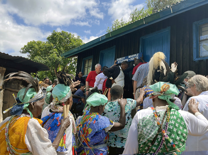 Neighbors join religious and hospital leaders in dedicating a new home built by the Center for Health and Hope in collaboration with Maua Methodist Hospital. Former Bishop Catherine Mutua of the Methodist Church in Kenya is seen praying at the left-hand corner of the home. Photo courtesy of the Rev. Donald E. Messer.