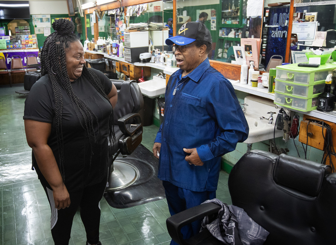 Tonya Bosley shares a laugh with her father, Jake Sherrell, at the barbershop where they both work. Photo by Mike Dubose, UM News.