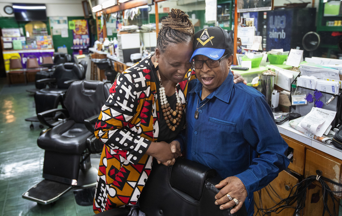 The Rev. Paula Smith embraces Jake Sherrell while they sing hymns together at Sherrell’s barbershop. Smith is pastor of Gordon Memorial United Methodist Church in Nashville. Photo by Mike Dubose, UM News.