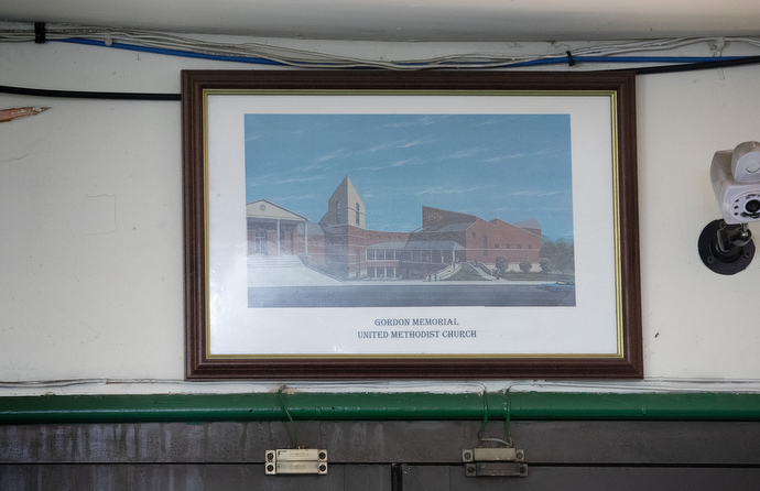 A photo of Gordon Memorial United Methodist Church hangs above the front door of Jake Sherrell’s barbershop. “If you come in here and want me to cut your hair, we’re going to bring up in conversation somewhere down the line how you feel about joining this church,” he said. Photo by Mike Dubose, UM News.