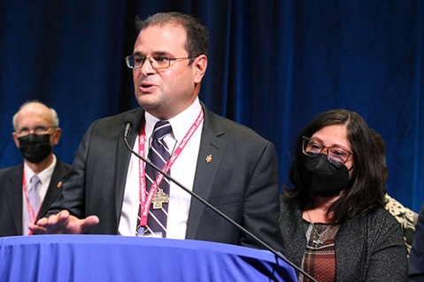 The Rev. Héctor A. Burgos-Núñez addresses the Northeastern Jurisdictional Conference after being elected bishop on Nov. 2. Burgos, who has been serving as a district superintendent in the Greater New Jersey Conference, was elected on the third ballot. His wife, Jazelis Burgos, is at his side. The conference is meeting Nov. 2-4 in College Park, Md. Photo by the Rev. Thomas Kim, UM News.