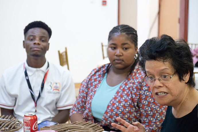 The Rev. Jennifer Jue (right) of the Michigan Conference talks with scholarship recipients at Africa University in October. Jue said the students talked about the unique way the university brings together people from different countries throughout Africa. Jue has started an endowed scholarship for a female student in the theology department. Photo by Kathy L. Gilbert.