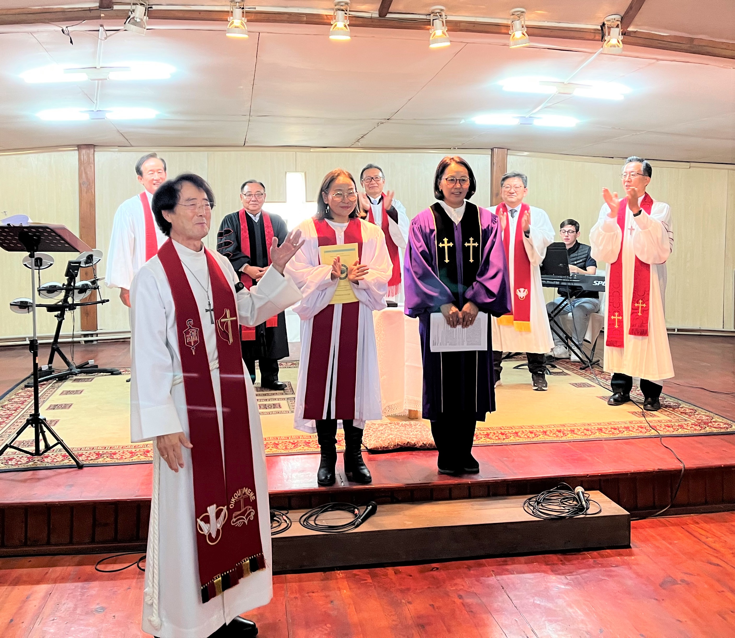 2022년 10월 3일, 몽골의 수도 울란바토르에 소재한 게렐트연합감리교회(Gerelt UMC)에서 열린 안수 예배를 마친 후, 박정찬 감독(맨 앞)이 연합감리교 몽골선교구의 최초 장로 목사인 우르징크한드(Urjinkhand) 목사(보라색 가운)와 뭉크나란(Munkhnaran) 목사(흰색 가운)를 소개하고 있다. 사진 제공, 연합감리교 세계선교부 아시아사무소.
