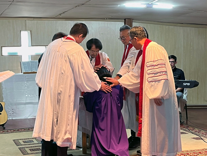 Bishop Jeremiah Park (center) lays hands on the Rev. Urjinkhand, one of the first two local elders ordained during the Mongolian Mission Initiative’s annual meeting at Gerelt United Methodist Church in Ulaanbaatar, Mongolia, on Oct. 3. The gathering celebrated the 20th anniversary of United Methodist mission work in Mongolia. Photo courtesy of the Asia Regional Office, United Methodist Board of Global Ministries.