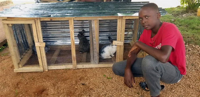 Juderbens Andy Hyppolite poses with his animals. The HAPIGro program includes monthly meetings with a worship component that allows the youth to share their experience. Photo courtesy of Valerie Mossman-Celestin, director of HAPI.