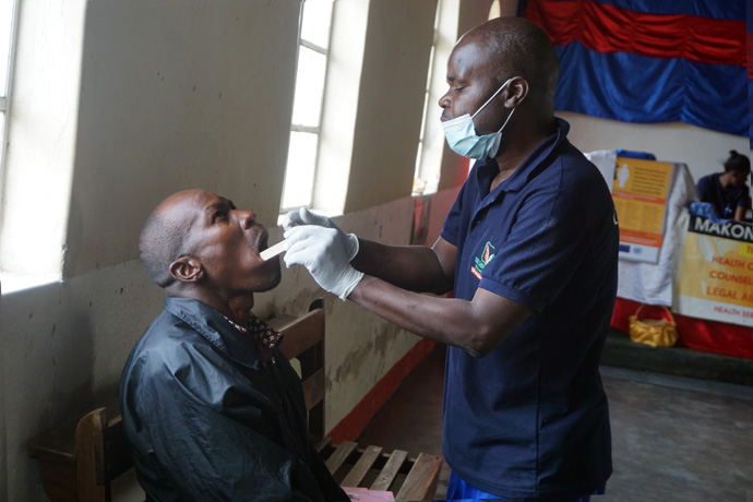 Dental therapist Strerlock Gondo attends to Galenth Mungure during a medical outreach program  sponsored by Runyange United Methodist Church in a remote area near Rusape, Zimbabwe. The program enabled villagers to get medical treatment without incurring costs of transport or hospital fees. Photo by Kudzai Chingwe, UM News.