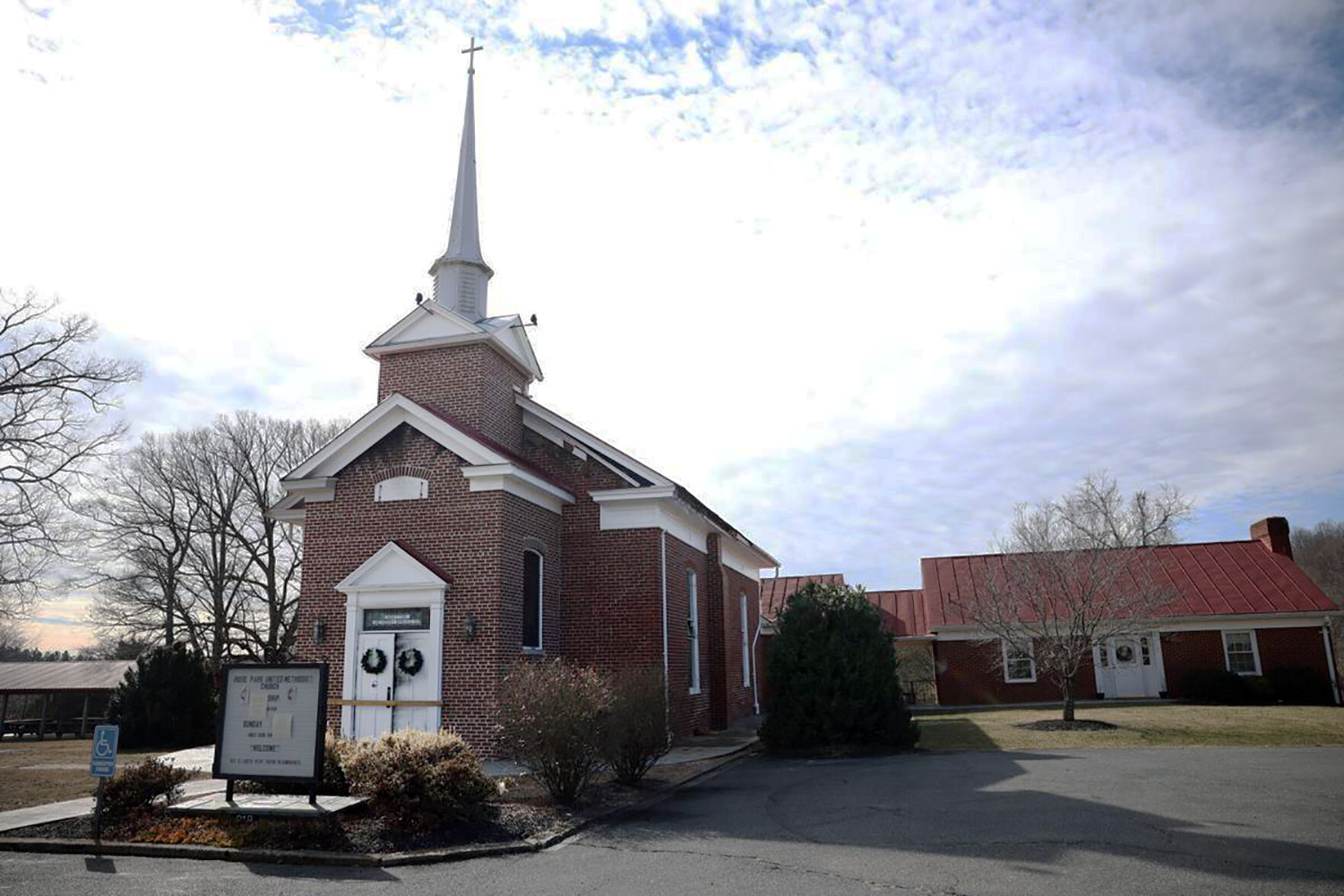 As portas do santuário da Igreja Metodista Unida de Rose Park estão carbonizadas e bloqueadas após um incêndio na semana passada. Notas coladas na placa em frente expressavam que ninguém foi ferido e direcionava os visitantes da igreja a comparecer ao culto na Igreja Metodista Unida Madison. Uma nota separada apresentava Isaías 43: 2-3a, que faz referência a andar no fogo e não ser queimado. Foto Gracie Hart Brooks, cortesia de The Daily Progress.