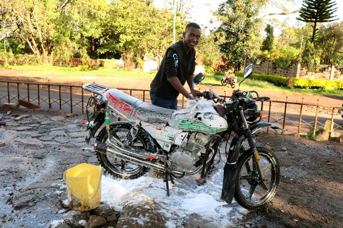 Berez Mutwiri, a member of Youth for Christ in Meru, washes a motorbike at one of the car washes owned by the church youth program in Makutano, Eastern Kenya. Many youths in Meru prefer working in khat production, but Mutwiri says alternative entrepreneurial skills are offering new opportunities for youth. Photo by Gad Maiga, UM News.