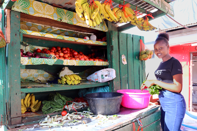 Leenet Gatwiri chops vegetables at one of the stores owned by Youth for Christ in Meru. Gatwiri runs the fresh vegetable store and believes the project has paved the way for youth in Kenya to raise from poverty to success. Photo by Gad Maiga, UM News.