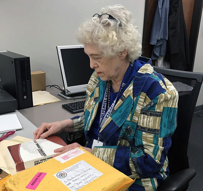 Frances Long, arquivista da Primeira Igreja Metodista Unida em Richardson, Texas, e da Jurisdição South Central, examina um manual de conferência. Foto cortesia da Conferência North Texas.