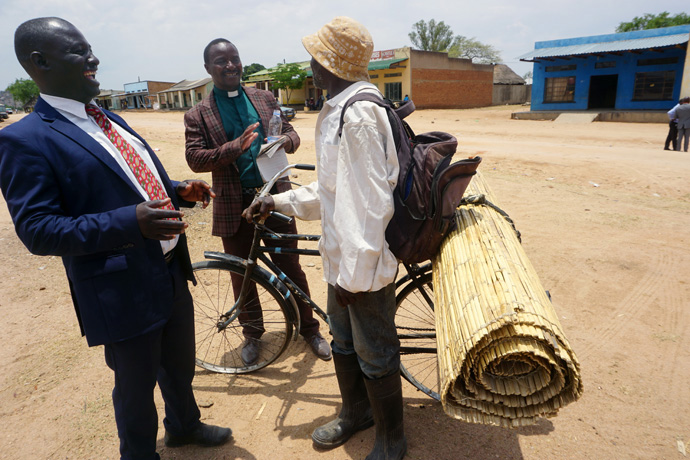 Eliah Chitakure, pastor-in-charge of the Buhera West Mission Area (left), and the Rev. Lloyd Rafemoyo (middle), district connectional ministries director, talk with Abot Matenga, who sells mats, during a three-day evangelism event of the church in Zimbabwe. Rafemoyo said crusades are the best way of “winning back lost members and reaching out to church seekers.” Photo by Kudzai Chingwe, UM News.