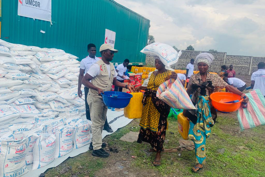Jean Tshomba, coordinateur du bureau de gestion des catastrophes de l'UMCOR dans l'est du Congo, livre de la nourriture et d'autres articles de secours à une femme déplacée par la guerre.  Selon les données fournies par le Bureau de la coordination des affaires humanitaires des Nations unies, plus de 521 000 personnes, principalement des femmes et des enfants, vivent dans des familles d'accueil ou dans des sites pour personnes déplacées dans la région.  Photo de Chadrack Tambwe Londe, UM News.