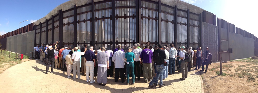 En mayo de 2013 obispos/as metodistas unidos de todo el mundo visitaron la frontera con México. En la foto de archivo los/as obispos/as, junto levantan las manos en oración en el Parque de la Amistad del lado estadounidense, mientras otro grupo de líderes de la comunidad fronteriza, de la Iglesia Metodista de México y familiares de inmigrantes, hace lo mismo del lado mexicano desde el Parque El Faro en Tijuana. Foto David Valera, Noticias MU.