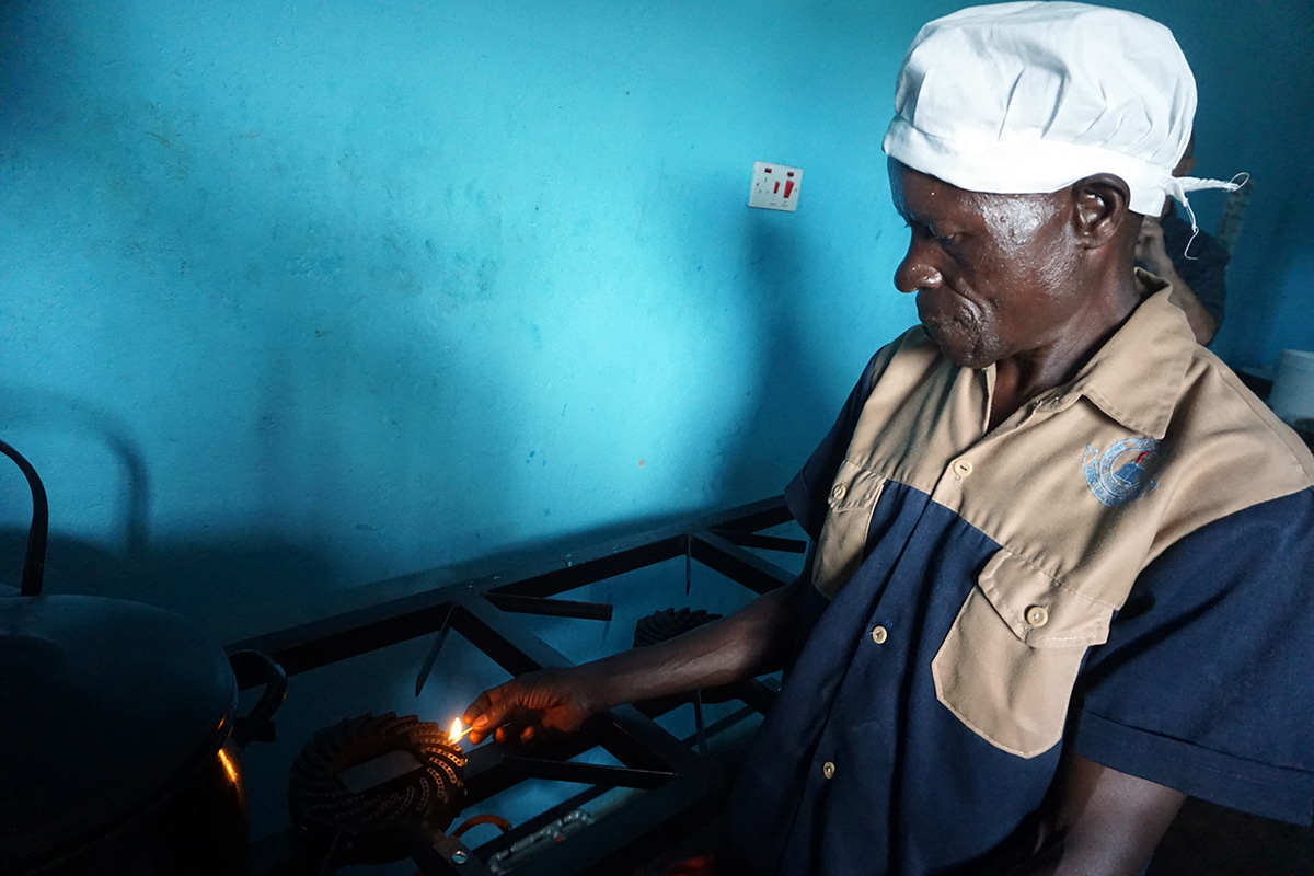 Samuel Musareka, Nyadire Central Primary School head cook, lights the stove to prepare a meal. The Nyadire Connection teamed up with Carnegie Mellon University students to install a biogas digester at the United Methodist mission school in Mutoko, Zimbabwe. Photo by Kudzai Chingwe, UM News.