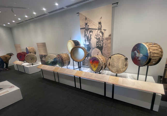 A visitor to the First Americans Museum in Oklahoma City on March 9, 2023, examines a Native American drum in the Voices from the Drum exhibit. Photo by Jim Patterson, UM News.