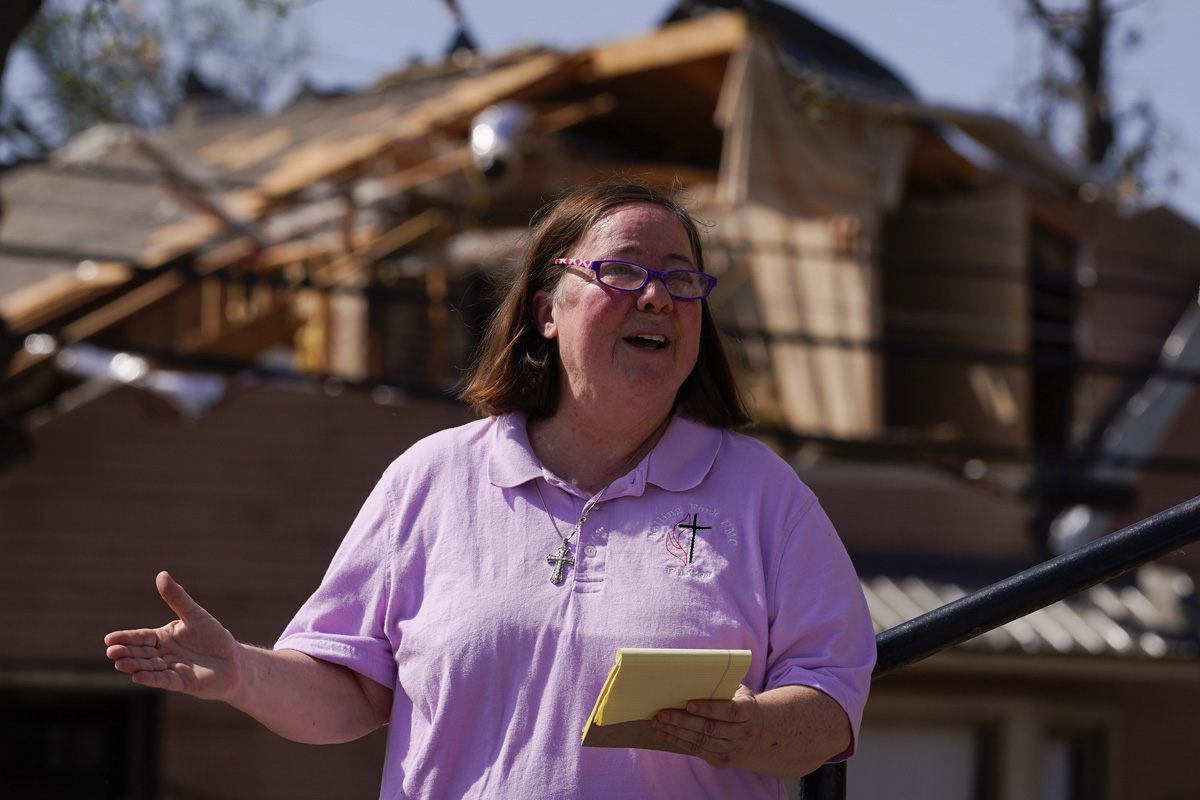 La Revda. Mary Stewart de la Iglesia Metodista Unida de Rolling Fork, Mississippi dirige una oración mientras la gente adora en los escalones de la iglesia el 26 de marzo. Al menos 25 personas murieron a causa de los tornados que azotaron el estado el 24 de marzo, destruyendo edificios y ocasionando cortes de energía a medida que el clima severo se movía a través de varios estados del sur. Foto Julio Cortés, AP.