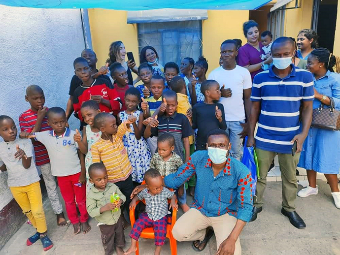 Innocent P. Afful (ajoelhado, de camisa azul), um missionário da Junta dos Ministérios Globais da Metodista Unida, posa com crianças de um orfanato apoiado pela igreja em Kinshasa, Congo. Afful faleceu em 17 de Abril aos 49 anos. Foto fornecida anteriormente por Innocent Afful.