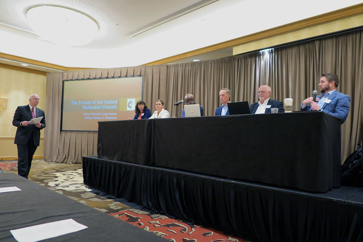 During the April 29 meeting of United Methodist bishops, chancellors and other conference leaders, a panel convened to discuss the ramifications of divisions and disaffiliations within the denomination. From left, Council of Bishops President Thomas Bickerton (standing); Courtney Kellner, Kentucky Conference chancellor; Texas Conference Bishop Cynthia Fierro Harvey; North Katanga Area Bishop Mande Muyombo; Florida Conference Bishop Tom Berlin; Tom Starnes, Baltimore-Washington Conference chancellor; and Bryan Mills, general counsel for the General Council on Finance and Administration. Photo by Heather Hahn, UM News.
