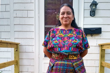 Maria Chavalan Sut frente a la casa de tres habitaciones que alquila con sus cuatro hijos en Charlottesville, Virginia. Chavalan Sut huyó de su Guatemala natal en 2015 y pasó tres años en el santuario de la Iglesia Metodista Unida Memorial Wesley antes de recibir una suspensión de su proceso de deportación en 2021. Foto cortesía de Richard Lord. Maria Chavalan Sut frente a la casa de tres habitaciones que alquila con sus cuatro hijos en Charlottesville, Virginia. Chavalan Sut huyó de su Guatemala natal en 2015 y pasó tres años en el santuario de la Iglesia Metodista Unida Memorial Wesley antes de recibir una suspensión de su proceso de deportación en 2021. Foto cortesía de Richard Lord.