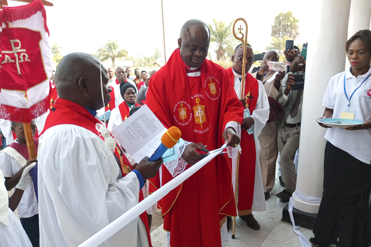 L'Evêque Mande Muyombo coupe le ruban lors de l'inauguration de l'Eglise Méthodiste Unie Banza Kaluwashi à Kabalo, au Congo, en juin. L'église porte le nom d'un missionnaire laïc congolais, ancien esclave, qui a implanté des églises dans la région au début des années 1900. Photo de Betty Kazadi Musau.
