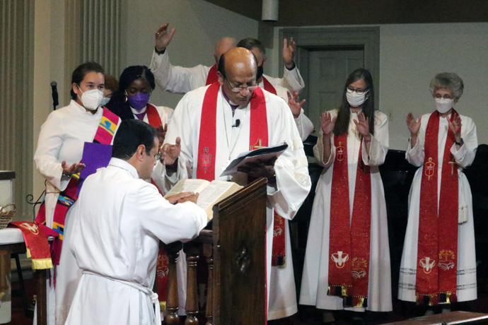 United Methodist Bishop Sudarshana Devadhar (center) leads the installation service of newly elected Bishop Héctor A. Burgos-Núñez (kneeling) on Nov. 5, 2022, during the Northeastern Jurisdictional Conference. Bishop Peggy Johnson, Interim bishop for the New England Conference, is pictured at far right. File photo by the Rev. Thomas Kim, UM News.