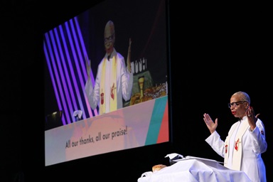 La Obispa Tracy S. Malone bendice los elementos de la comunión durante un servicio en la Conferencia Anual del Este de Ohio el 8 de junio. Malone es la coordinadora del grupo de trabajo conjunto que reunió a los/as miembros del Comité Permanente sobre Asuntos de la Conferencia Central, la Mesa Conexional y quienes desarrollaron el Pacto de Navidad para refinar la legislación propuesta que pondría a las diferentes regiones geográficas de la iglesia mundial en una posición más equitativa. Foto de archivo cortesía de la Conferencia Anual del Este de Ohio. La Obispa Tracy S. Malone bendice los elementos de la comunión durante un servicio en la Conferencia Anual del Este de Ohio el 8 de junio. Malone es la coordinadora del grupo de trabajo conjunto que reunió a los/as miembros del Comité Permanente sobre Asuntos de la Conferencia Central, la Mesa Conexional y quienes desarrollaron el Pacto de Navidad para refinar la legislación propuesta que pondría a las diferentes regiones geográficas de la iglesia mundial en una posición más equitativa. Foto de archivo cortesía de la Conferencia Anual del Este de Ohio.