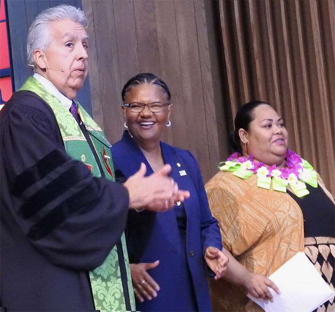 Bispo Ruben Saenz Jr., Sally Vonner (centro) e 'Ainise 'Isama'u sobem ao palco durante o serviço de posse de Vonner em 29 de julho como principal executiva da United Women in Faith (Mulheres Unidas na Fé). O culto foi na Igreja Metodista Unida Lovers Lane, em Dallas. Foto por Sam Hodges, Notícias MU.