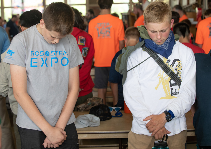Boy Scouts William Riley (left) and Colin Harward pray before lunch at the Boxwell Scout Reservation. Photo by Mike DuBose, UM News.