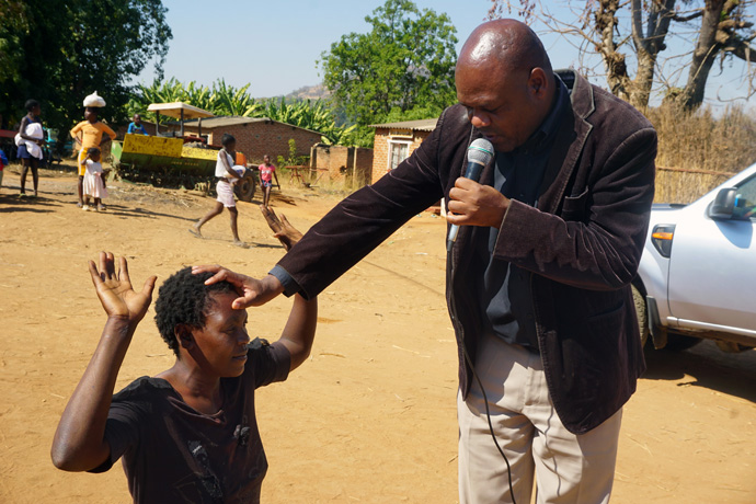 Associate Pastor Mabasa Muzhizhizhi blesses Miriam Chakwenya on June 17 during an evangelism tour that included preaching, teaching and music to connect with people in farming areas in the Zimbabwe Episcopal Area. Chakwenya was not feeling well and welcomed the chance to be prayed for by the pastor. Photo by Kudzai Chingwe, UM News.