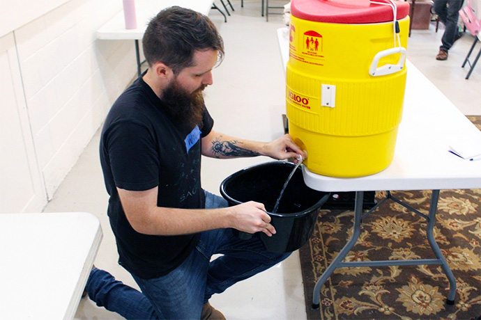 Will Compton, resource specialist for Open Table Nashville, fills a foot bath during a Tuesday evening foot clinic at Trinity Community Commons in East Nashville, Tennessee. Volunteers care for recipients’ feet, offering nail trimming, callus scrubbing and basic wound care if needed. Photo by Vernon Jordan, UM News.