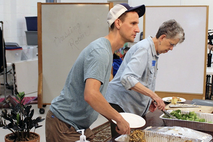 Zach Lykins and volunteer Evelyn Hale serve visitors at Trinity Community Commons in East Nashville, Tennessee. Lykins is executive director of Trinity Community Commons, which hosts a community supper and foot clinic every Tuesday in May through September. Photo by Vernon Jordan, UM News.