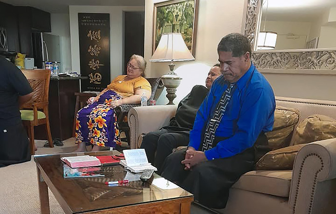 Membros da Igreja Metodista Unida de Lahaina rezam em um quarto de hotel em 13 de agosto. Seu santuário estava entre os prédios destruídos pelos incêndios florestais de 8 de agosto que devastaram a comunidade de Lahaina, Havaí. Foto cortesia da Igreja Metodista Unida de Lahaina. 