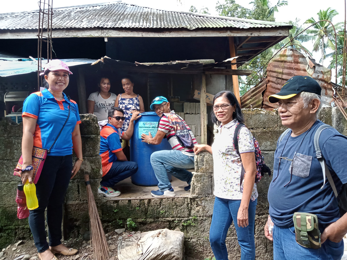 United Methodist pastors and disaster management team leaders evaluate a rainwater-harvesting tank that was installed a month earlier in the Novele community in the Davao Area of the Philippines. The United Methodist Church distributed the drums to more than 30 households and three community centers in the region. Pictured (from left to right) are the Rev. Marlyn N. Nabatilan, an unnamed neighbor, recipient Janeth Erandio, the Rev. Jerson Sanggo and team leaders Eddie Danglapen, Fe Tomas and Maurice Bigaran. Photo courtesy of the Rev. Dan Reuben L. Sison.