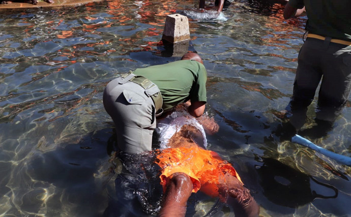 Chaplain Jefat Zhou immerses an inmate during a baptism event held by The United Methodist Church at Chikurubi Maximum Security Prison in Harare, Zimbabwe, on July 28. Hundreds of inmates were baptized as part of the church’s outreach ministry at the prison. Photo by Prudence Choto, Chikurubi Maximum Security Prison.