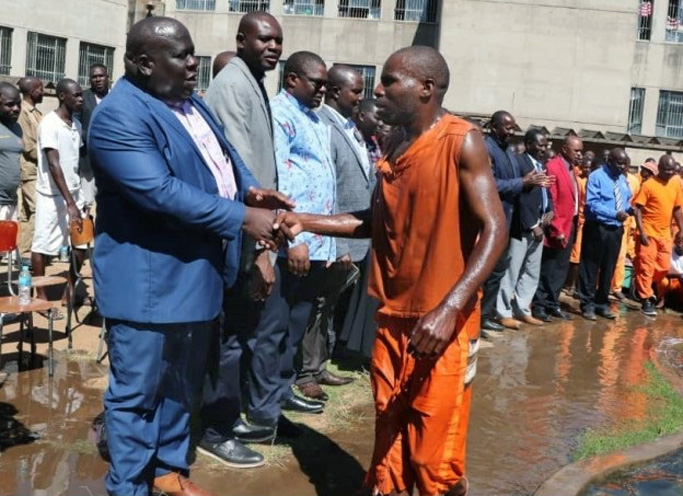 Harare East church leaders the Revs. Oscar Nyasha Mukahanana (left), David Mupaya and John Makaniko congratulate an inmate who was baptized on July 28 at Chikurubi Maximum Security Prison in Harare, Zimbabwe. Mukahanana, a district superintendent, encouraged inmates to accept Jesus Christ as their Savior, regardless of the seriousness of their crimes. Photo by Prudence Choto, Chikurubi Maximum Security Prison.