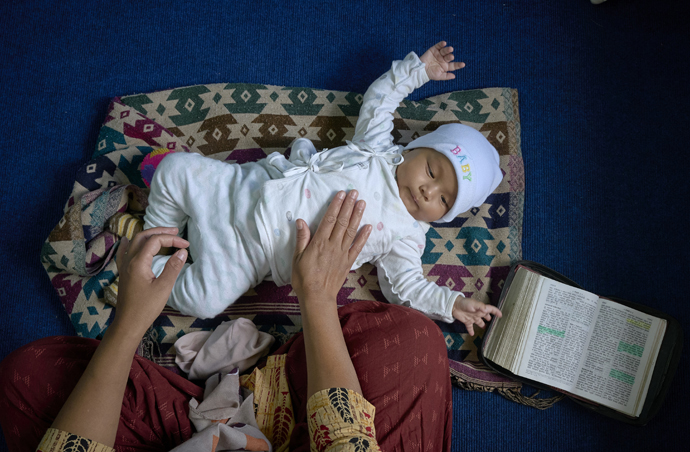 Yamimah de 5 meses, juega en el suelo mientras su madre Chameli Rai, participa en un seminario ecuménico sobre mujeres y liderazgo el 23 de mayo en la Iglesia Metodista Unida de Hebrón en Lalitpur, Nepal. El taller fue copatrocinado por Mujeres Unidas en la Fe. Foto de Paul Jeffrey, Noticias MU.